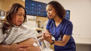 A nurse helping a mother in a delivery room